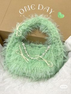 a green purse sitting inside of a box