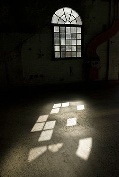 an empty room with three windows and no one is in the photo or there is also light coming through the window