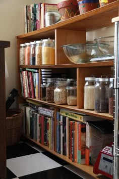 the shelves in this kitchen are filled with books and other things to cook for dinner