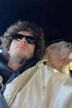 a man and his dog are sitting in the back seat of a car with sunglasses on