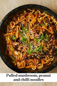 a bowl filled with noodles and vegetables on top of a table