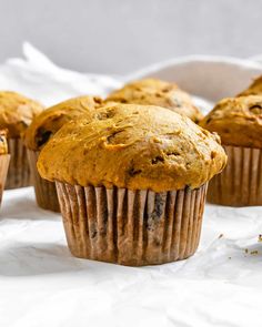 several muffins sitting on top of a white table cloth next to each other