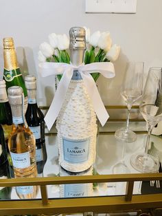 bottles of champagne and wine glasses on a glass shelf