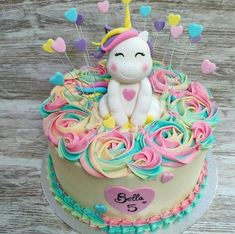 a birthday cake with a unicorn on top and hearts around the edges that spell out love