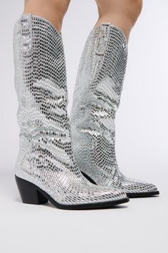 The AZALEA WANG Driven Rhinestone Western Boot In Silver is made from a glimmering rhinestone embellished upper and features a Western-inspired, rounded below-the-knee height shaft. Complete with a chunky heel, pointed toe, and pull on fit.  Psst, this style runs large. We recommend sizing down one half size.   Fit and details (approx. measured from a US women’s size 7.5):  - Textile Upper - Pointed Toe - Chunky Heel - 15” Shaft Height - 3” Heel Height - Imported  Product ID: 335743 Azalea Wang, One Half, Western Boot, Thigh High Boots, Chunky Heel, Western Boots, Thigh Highs, Chunky Heels, High Boots