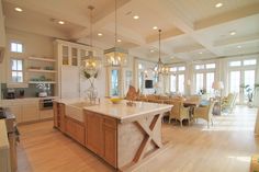 a large open concept kitchen and dining room with wood floors, white walls and ceiling