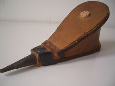 an old wooden object with a long horn on it's end and a hole in the middle