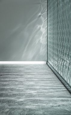 an empty room with a glass wall and tile flooring on the ground, in front of a gray sky