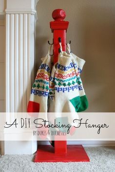 a red coat rack with two sweaters hanging from it's sides and the words, a diy stocking hanger