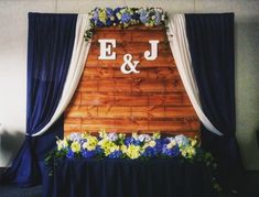 a wooden wall with flowers on it and the initials j and j are displayed above