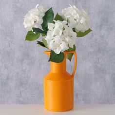 an orange vase with white flowers in it