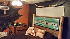 a bed with pillows and stuffed animals on it in a room that has an old truck painted on the wall