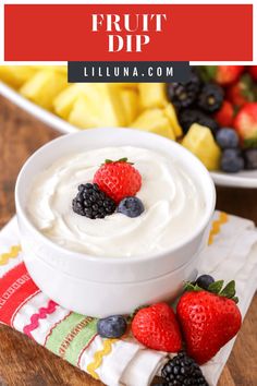 fruit dip in a white bowl with berries and pineapples on the side next to it