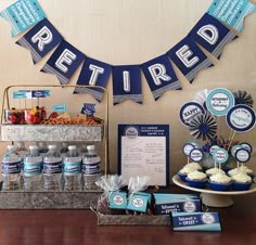 there is a dessert bar set up with blue and white decorations on the top shelf