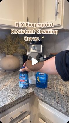 a person is cleaning the kitchen counter with disinfectant and sprays on it