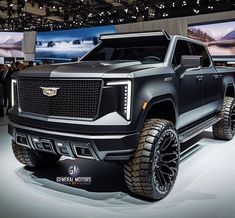 a black truck is on display at an auto show