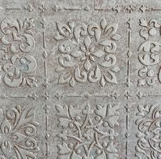 an old cement wall with decorative designs on it