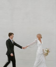 a bride and groom are holding hands