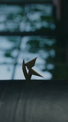 a pair of scissors sitting on top of a piece of black paper in front of a window