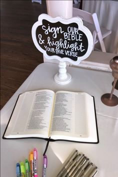 an open book sitting on top of a table next to some markers and crayons