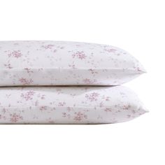 two pillows with pink flowers on them sitting next to each other in front of a white background