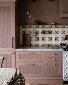 a kitchen with pink cabinets and an oven