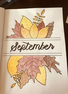 an open book with autumn leaves and the word november written on it in black ink