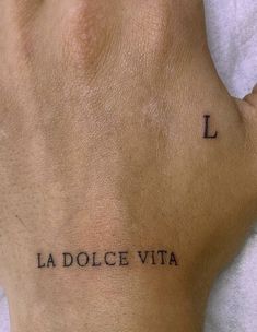 a hand with the word la dolce vita tattooed on it's left side