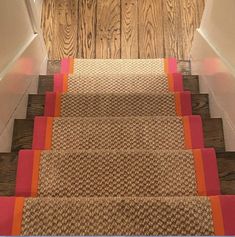 the carpeted stairs are lined with orange and pink strips