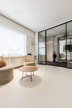 a living room filled with furniture next to a large glass wall window covered in mirrors