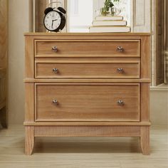 a wooden dresser with an alarm clock on top