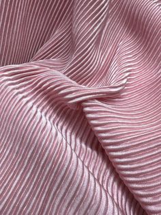 a pink and white striped fabric is shown in close up view, with the folds on it