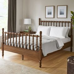 a bed with white sheets and pillows in a bedroom next to a wooden flooring