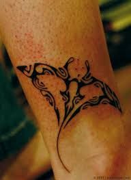 a woman's foot with a tattoo design on the side of her leg,