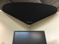 a flat screen tv mounted to the side of a wall next to a laptop computer