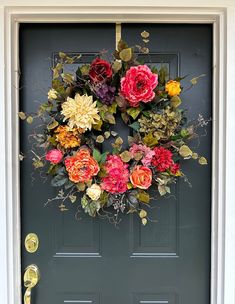 a front door decorated with flowers and greenery