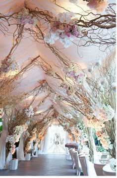 an aisle decorated with flowers and branches