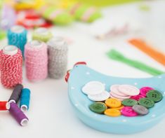 several different colored spools of thread and buttons