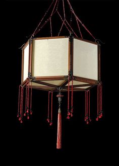 a chandelier with red beads hanging from it's sides and white panels