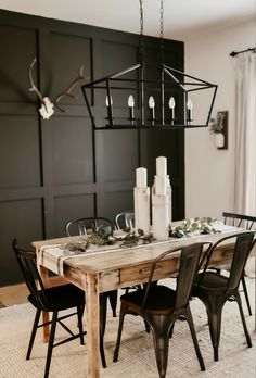 a dining room table with chairs and candles