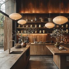 a kitchen filled with lots of wooden counter tops and hanging lights over the top of it