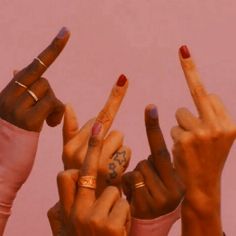 four fingers with different designs on them making the peace sign in front of a pink background