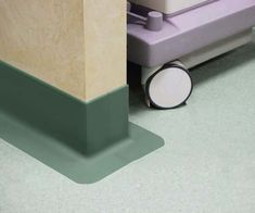 a close up of the corner of a room with a toilet and trash can on the floor