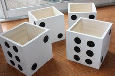 four white dices with black dots on them sitting on a wooden floor in front of a window