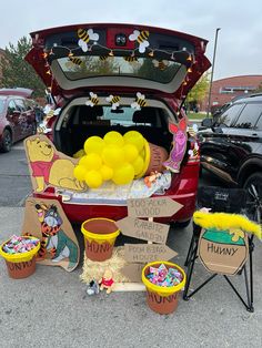 the trunk of a car is decorated with winnie the pooh balloons and other decorations