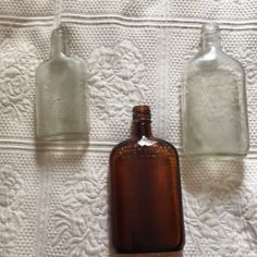 two empty brown glass bottles sitting next to each other on a white towel covered table