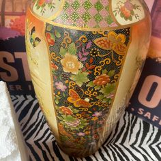 an ornate vase sitting on top of a zebra print table cloth