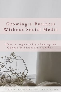 a white vase sitting on top of a wooden table next to a planter filled with flowers