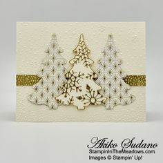 a card with a christmas tree and snowflakes on the bottom, in gold foil