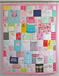 a pink and green patchwork quilt hanging on a wall